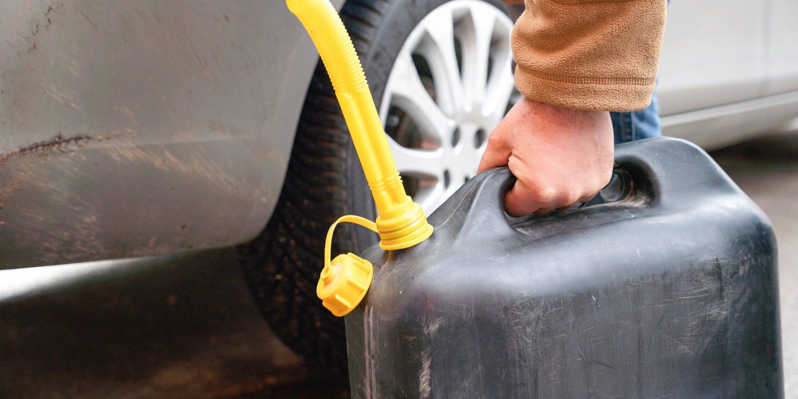 Person Filling Vehicle With Fuel From Portable Canister On Roadside Person Filling Vehicle With Fuel From Portable Canister On Roadside