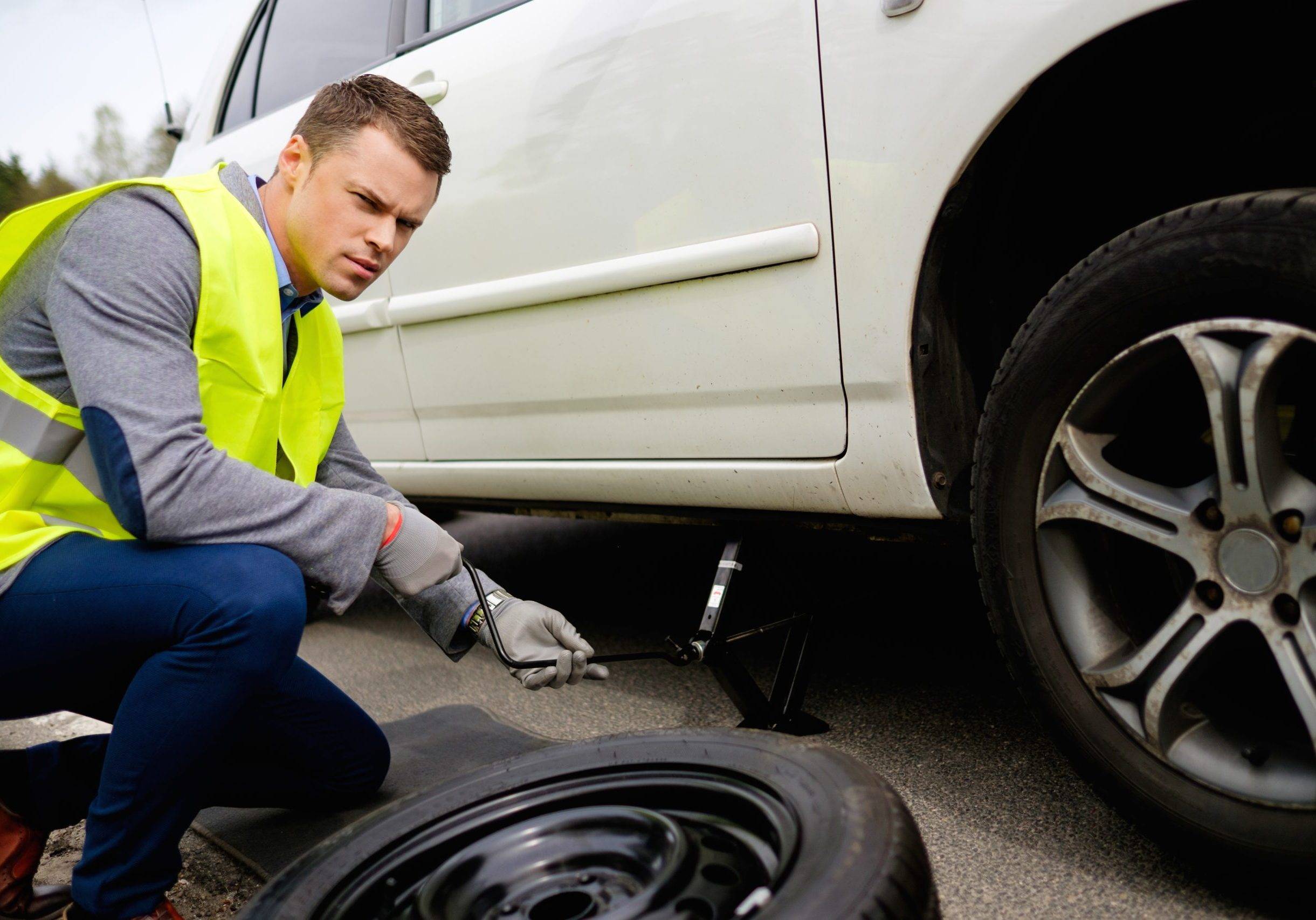 Man Changing Wheel On A Roadside Man Changing Wheel On A Roadside